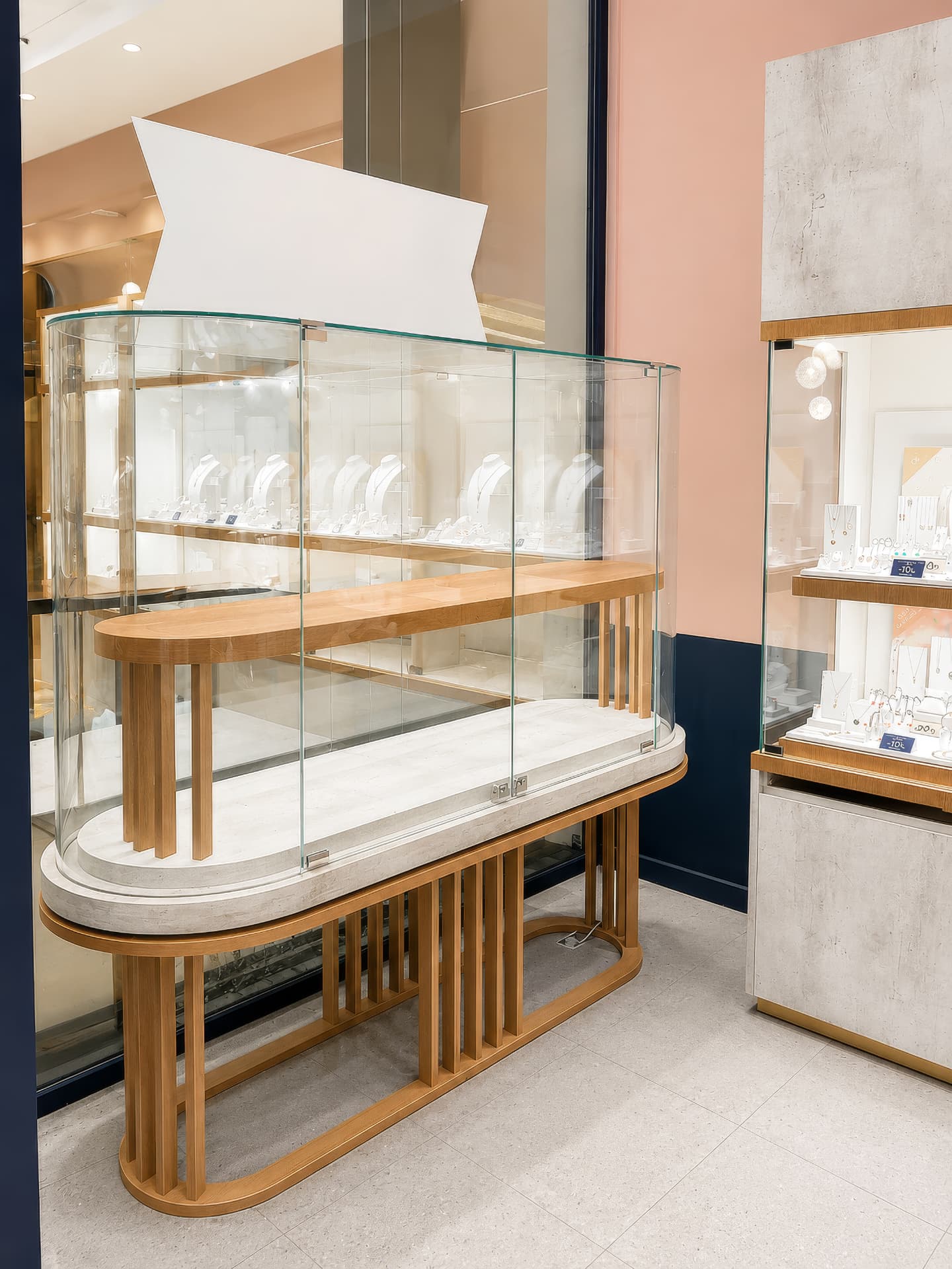 Tall curved glass vitrine with jewelry on display