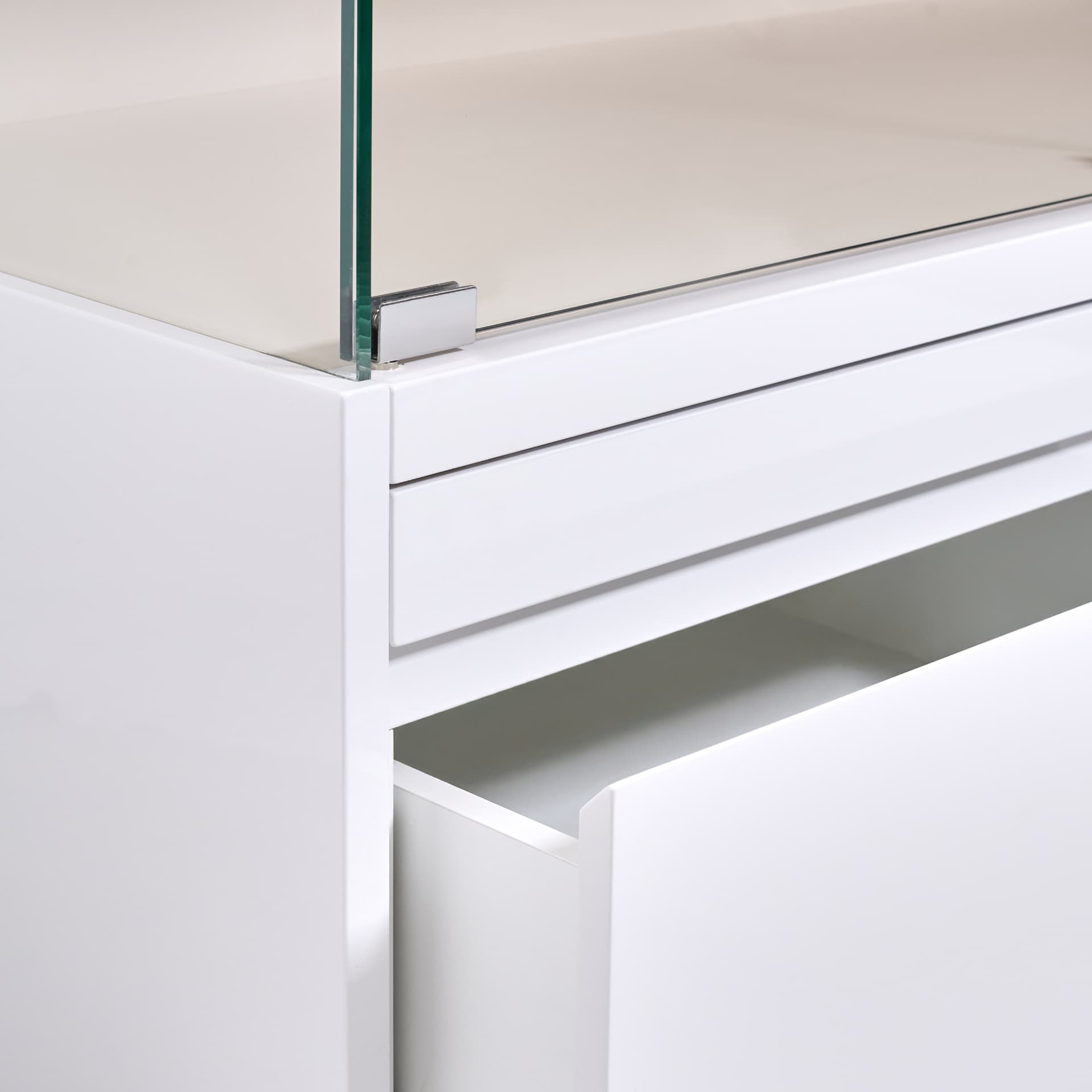 Detail of a white counter with tempered glass and open drawer