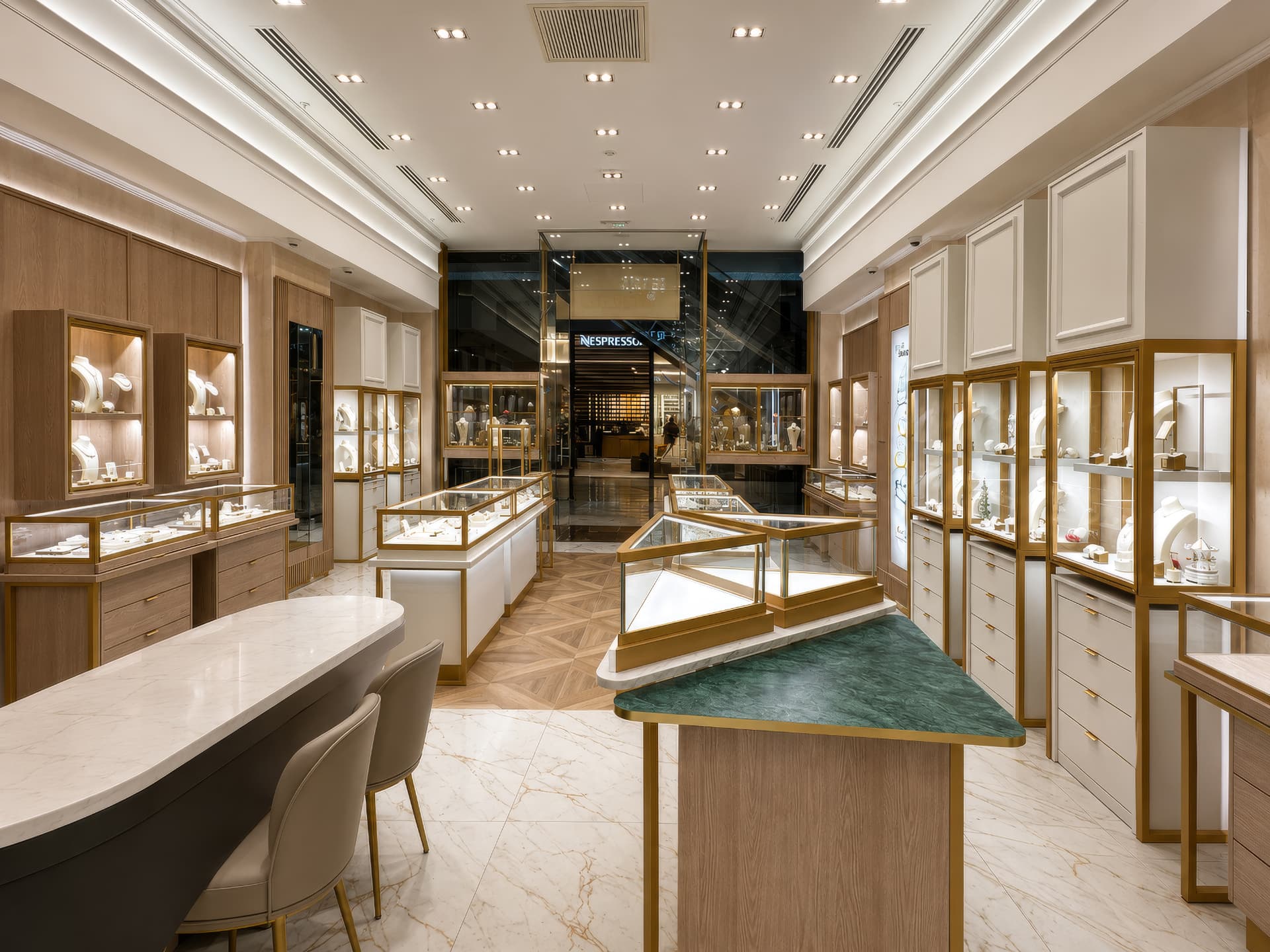 Long sales floor with oak wall vitrines and green marble consultation counter