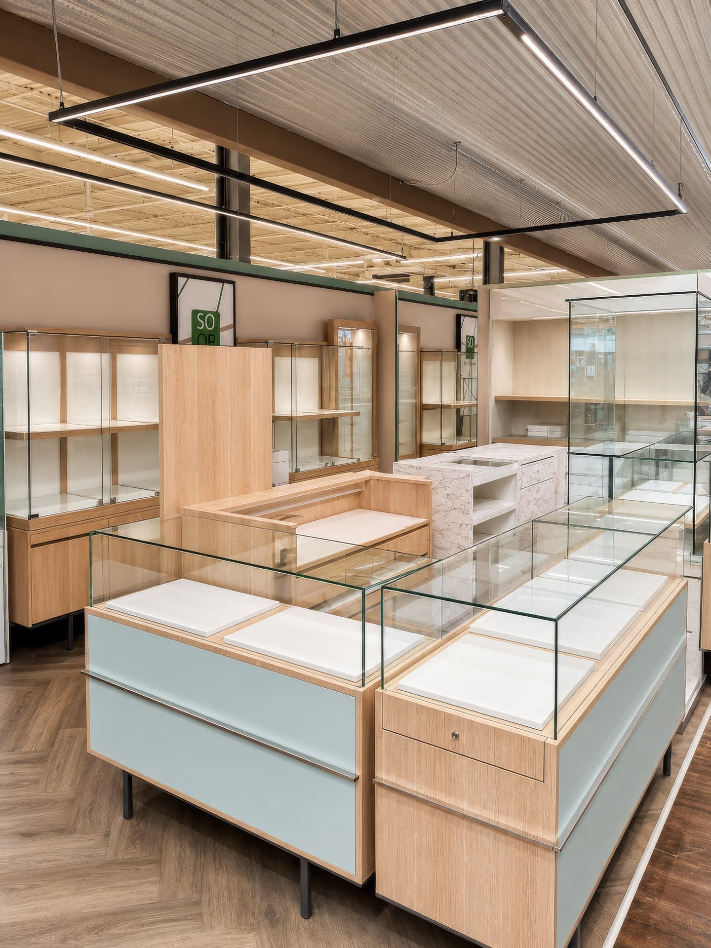 Perspective across sage island counters with lit glass display tops