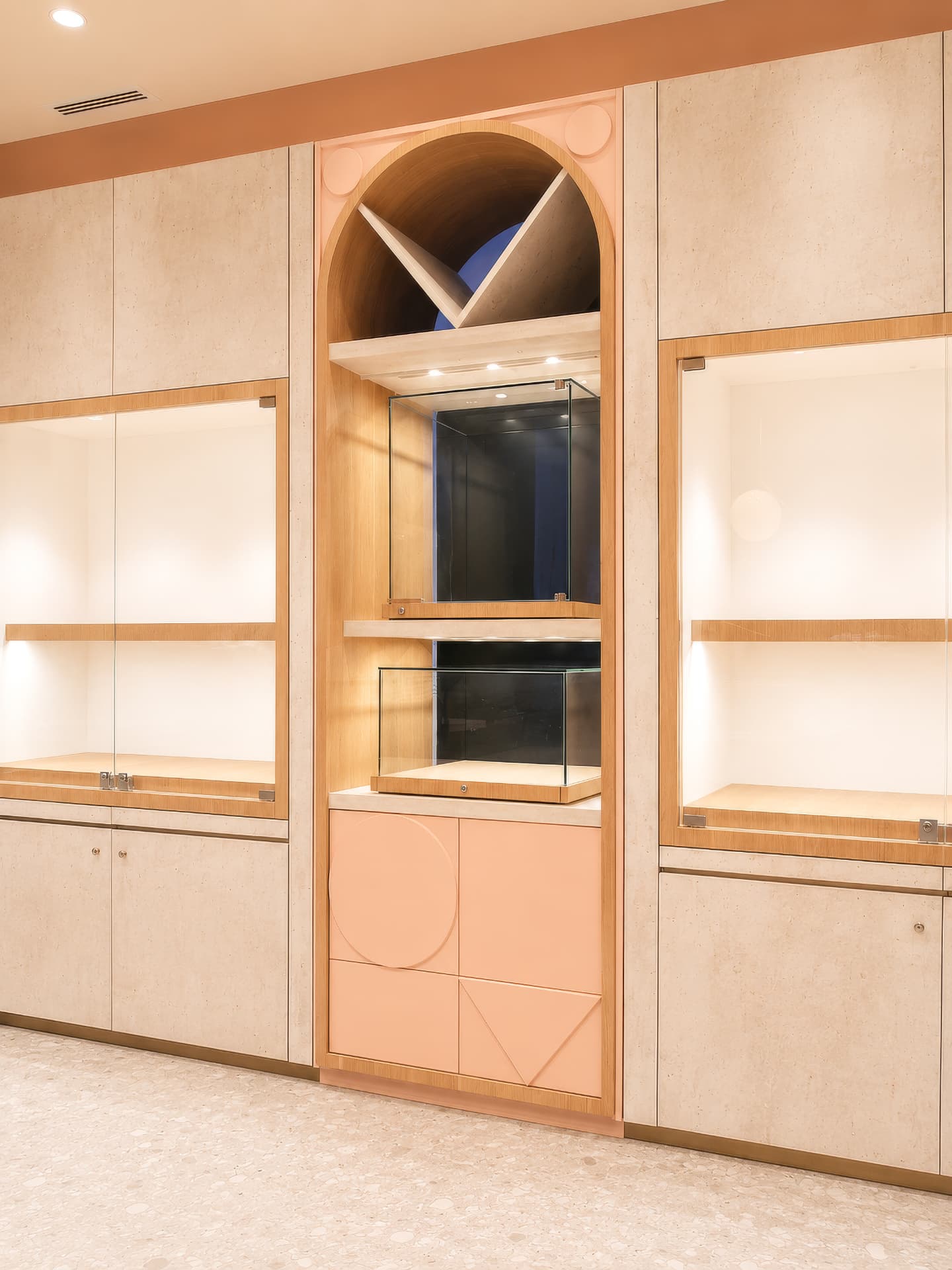 Arched display niche with blush fronts and glass cubes