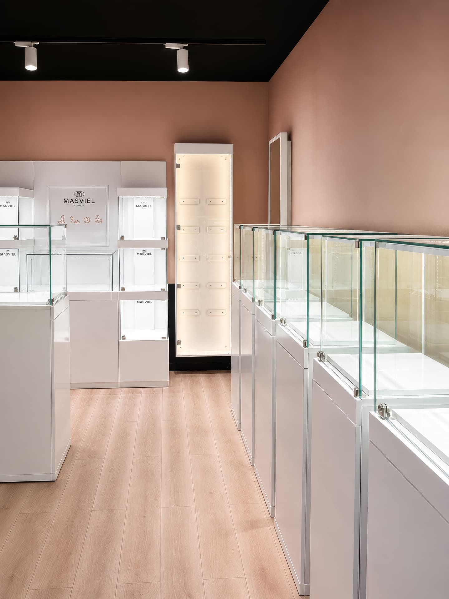 Boutique with white vitrines against terracotta walls and a lit display niche