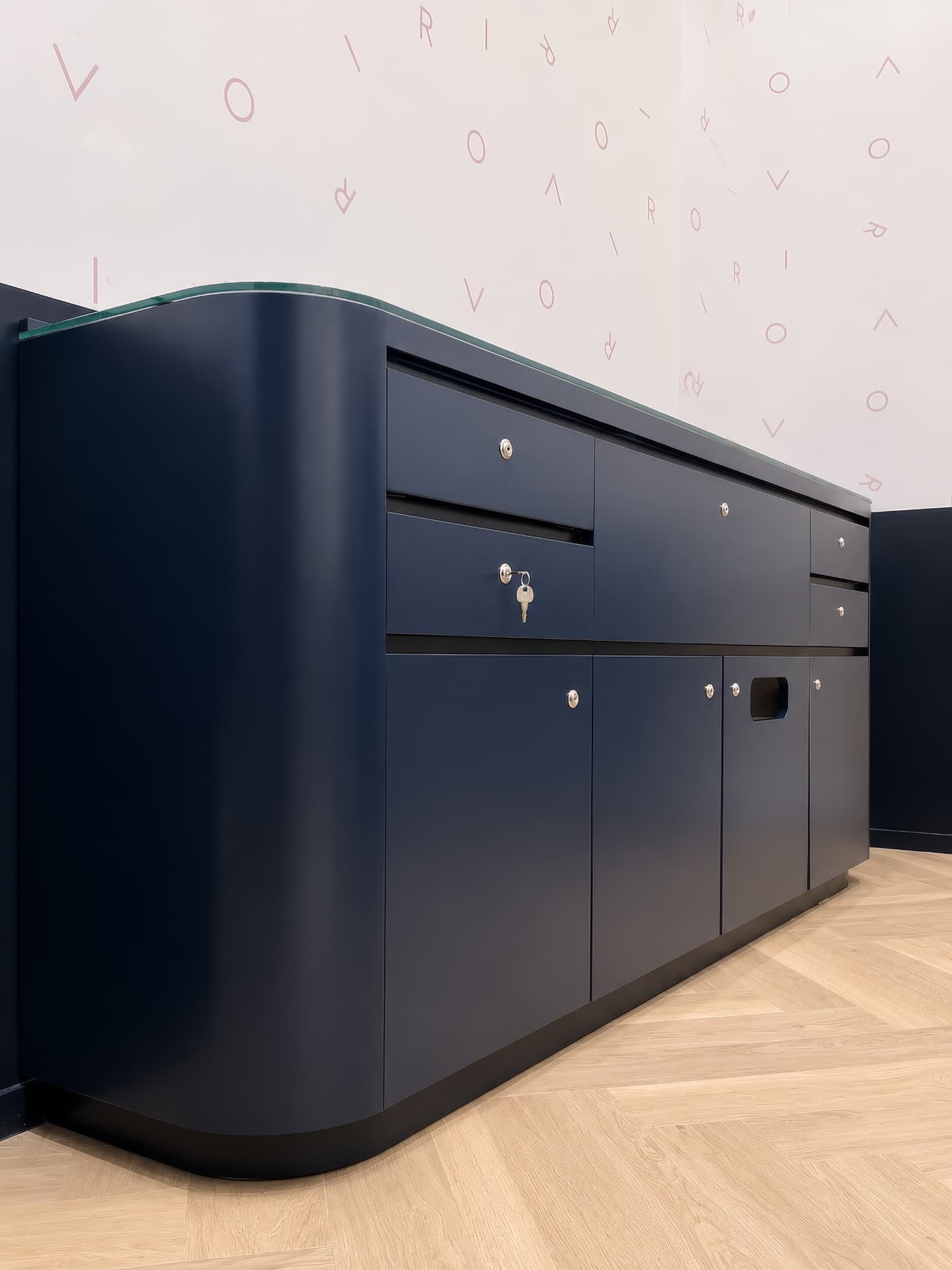 Navy lacquered storage counter with curved glass top