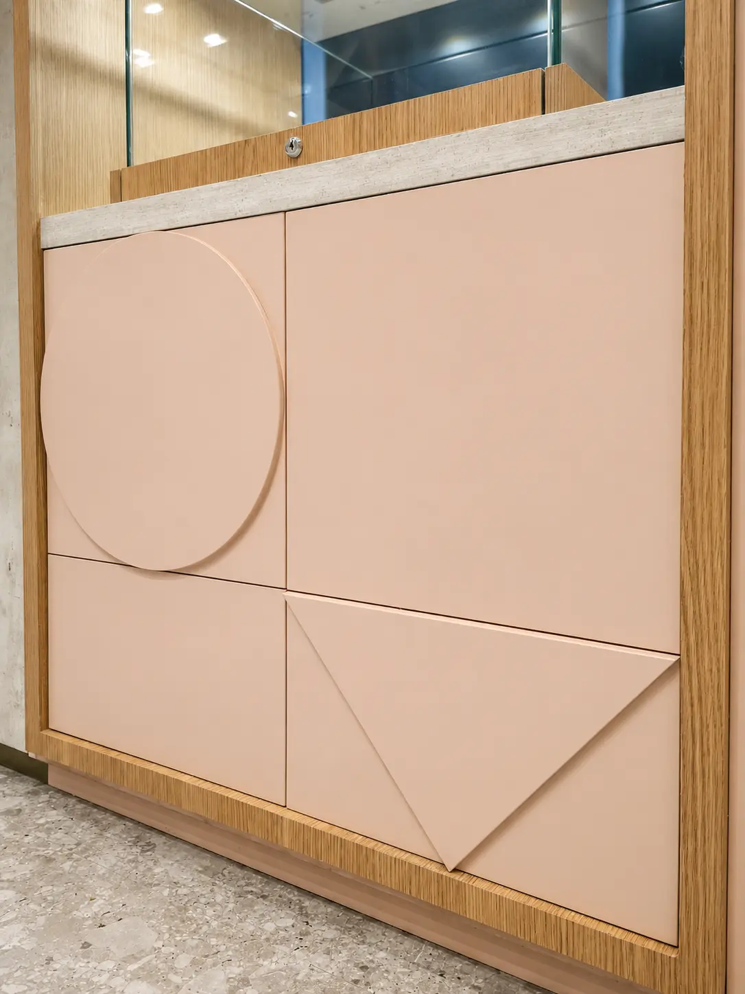 Detail of blush lacquered fronts with relief geometry