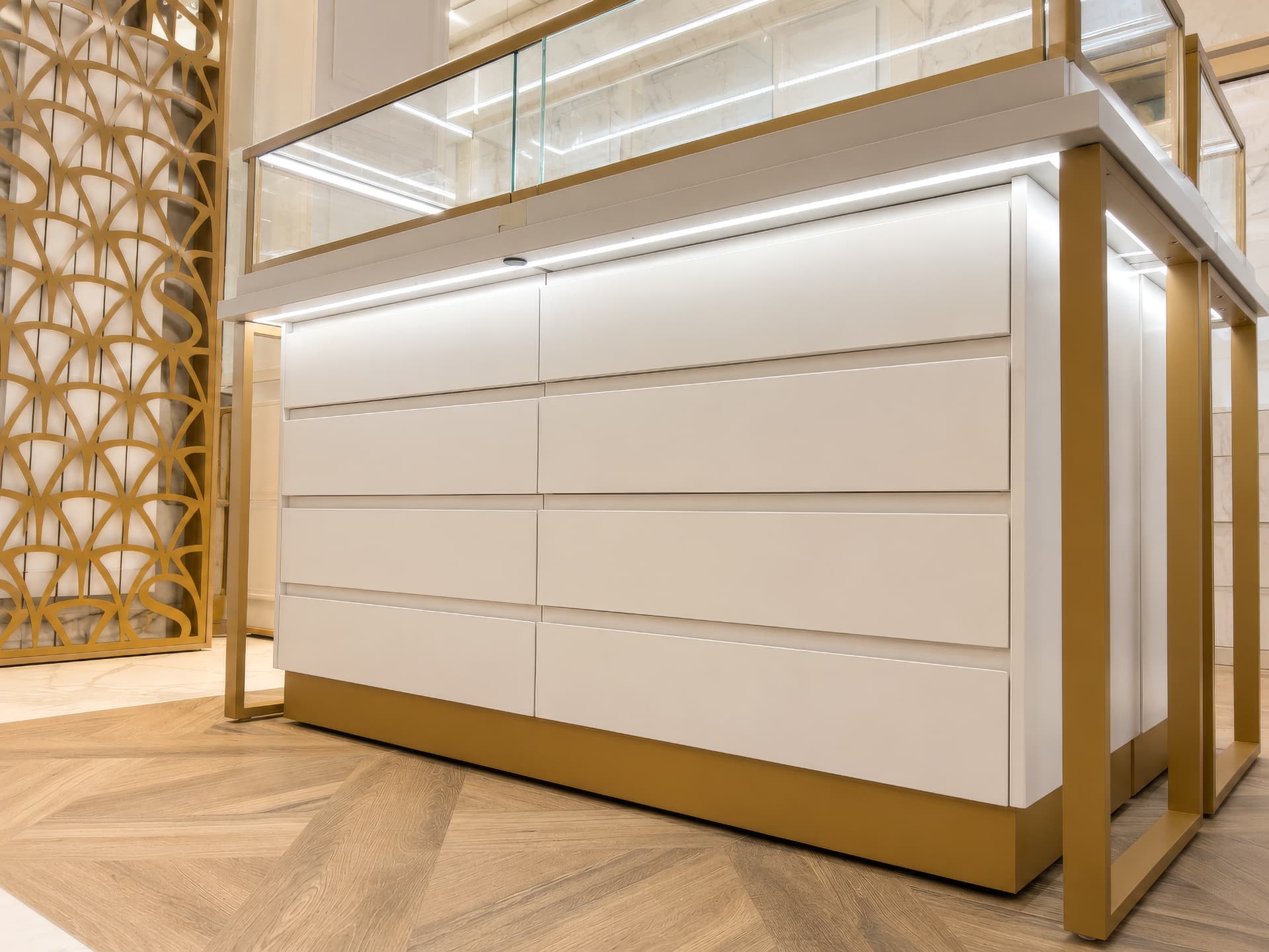 Lacquered drawer bank with brass plinth and lit glass top